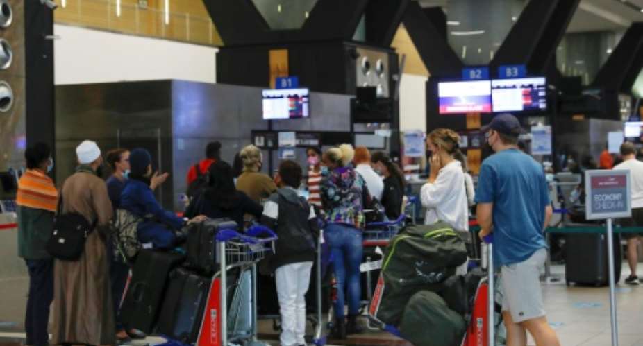 Travellers queue at check-in counters at Johannesburg international airport on Saturday after several countries banned flights from South Africa following the discovery of the new Covid-19 variant Omicron.  By Phill Magakoe AFP