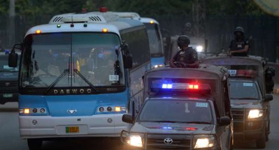 Security personnel escort buses carrying the Zimbabwe and Pakistani cricket teams as they leave a practice session at the Gaddafi Stadium in Lahore on May 19, 2015.  By Aamir Qureshi AFP