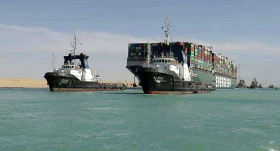 Tugboats guide the giant container vessel MV Ever Given through the Suez Canal after it was finally refloated, ending a near week-long closure of the vital trade artery.  By - SUEZ CANAL AUTHORITYAFP
