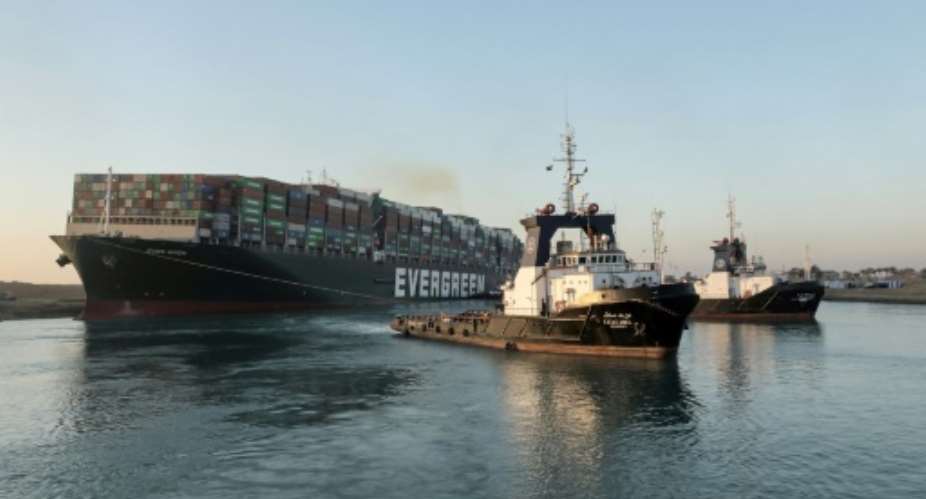 Tugboats pull the Panama-flagged MV Ever Given to unobtrusive sanctuary after its stern and bow were successfully prised from the banks of the Suez Canal.  By - SUEZ CANAL AUTHORITYAFP