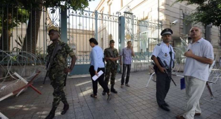 Tunisian police and soldiers stand guard in front of the French ambassy in Tunis.  By Fethi Belaid AFP