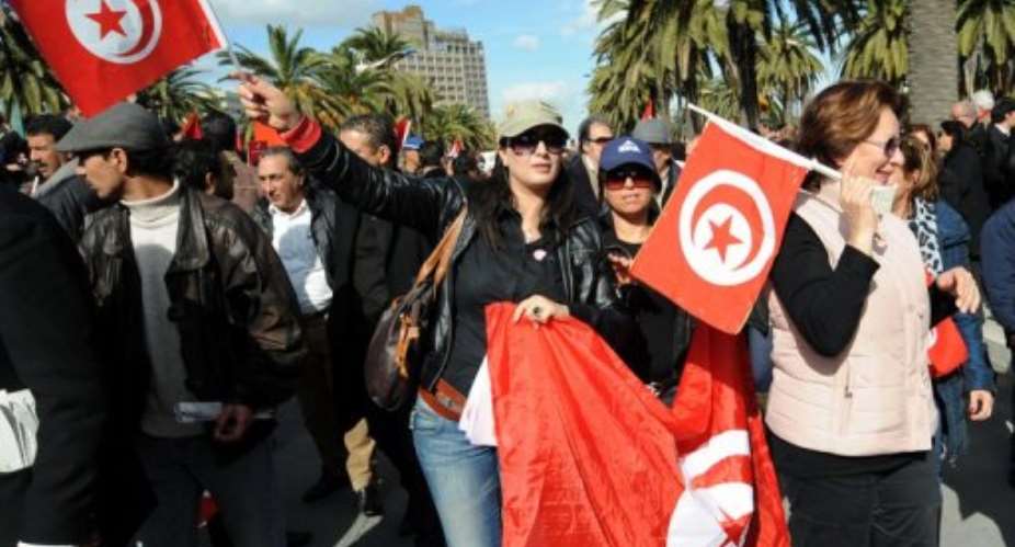 Tunisian people shout slogans and wave Tunisian flags during a demonstration on Habib Bourguiba Avenue in Tunis.  By Fethi Belaid AFPFile