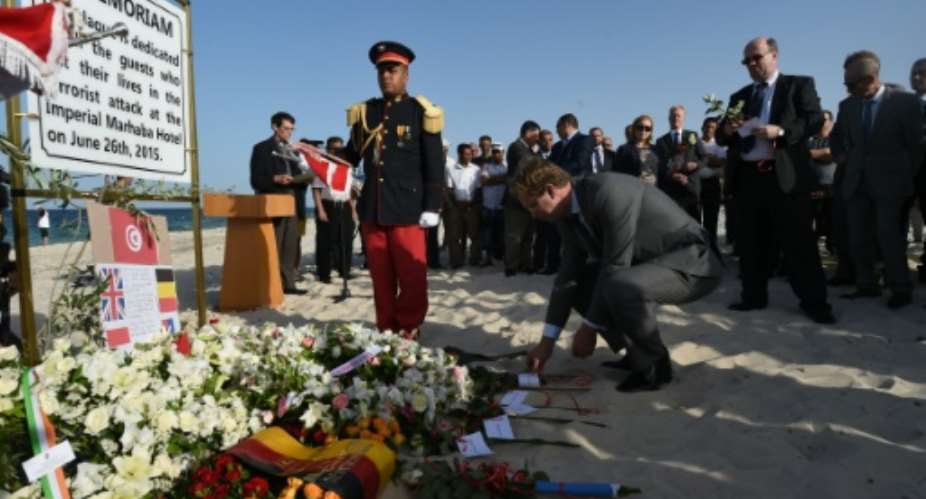 Britain's Foreign Office junior minister, Tobias Ellwood, lays a flower on the beach on June 26, 2016, during a ceremony in memory of those killed a year ago by a jihadist gunman in front of a hotel south of Tunis.  By Fethi Belaid AFP