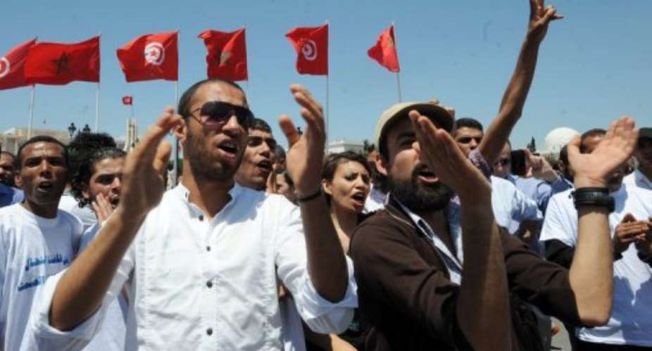 Young unemployed graduates shout slogans in Tunis.  By Fethi Belaid (AFP)
