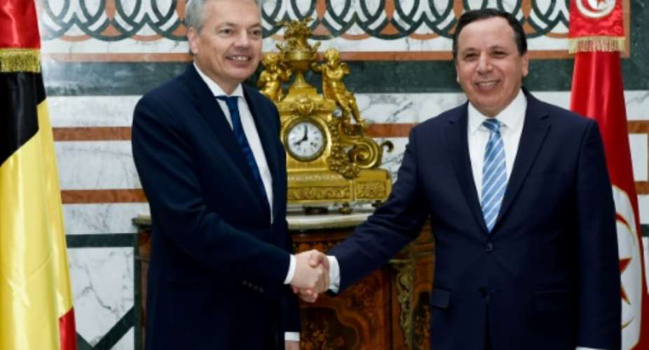 Tunisian Foreign Minister Khemaies Jhinaoui R greets his Belgian counterpart, Didier Reynders, during an official visit in the capital Tunis on March 1, 2017.  By FETHI BELAID AFP