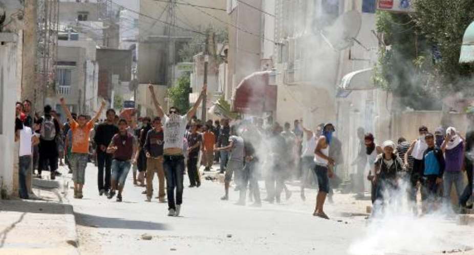 Tunisian police fire tear gas during clashes with radical Islamists on May 19, 2013 in a neighbourhood west of Tunis, after Salafist movement Ansar al-Sharia told its followers to gather.  By Khalil AFPFile