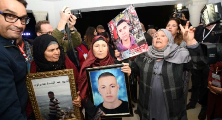 Tunisian mothers of a torture victims carry their sons' portraits as they arrive for a Truth and Dignity Commission hearing in Tunis on November 17, 2016.  By FETHI BELAID AFP