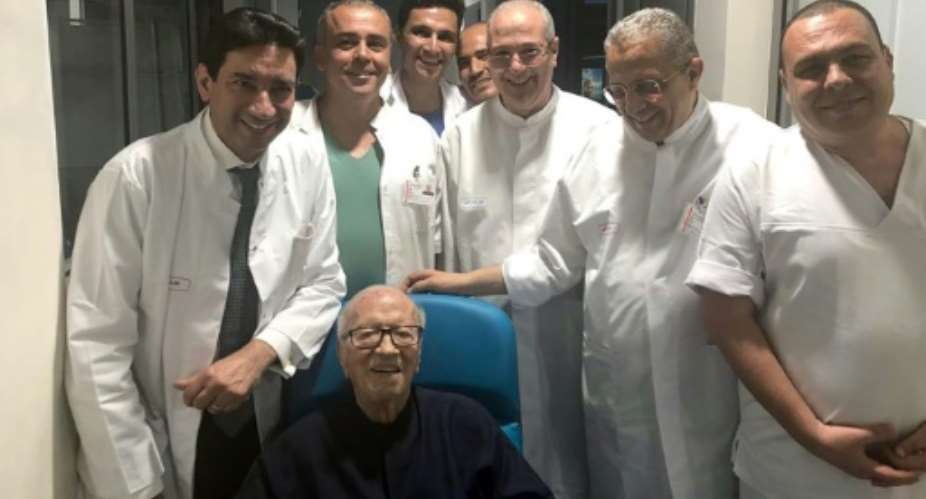 Tunisian President Beji Caid Essebsi smiles as he leaves hospital surrounded by his doctors.  By - Tunisian PresidencyAFP