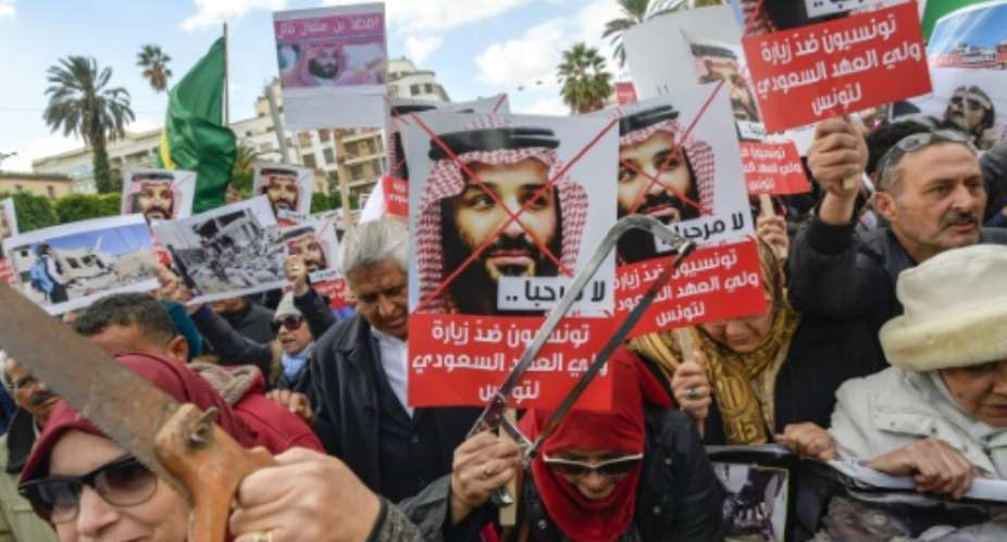 Tunisian women hold up saws and signs saying in Arabic, No welcome, Tunisians against the visit of the Saudi Crown Prince to Tunisia, during an anti-Saudi Crown Prince protest in Tunis on November 27, 2018.  By FETHI BELAID AFPFile