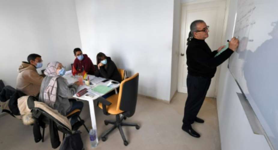 Tunisian Yeft Benazzouz R, who runs a language school in the capital Tunis, teaches a class German.  By FETHI BELAID AFP