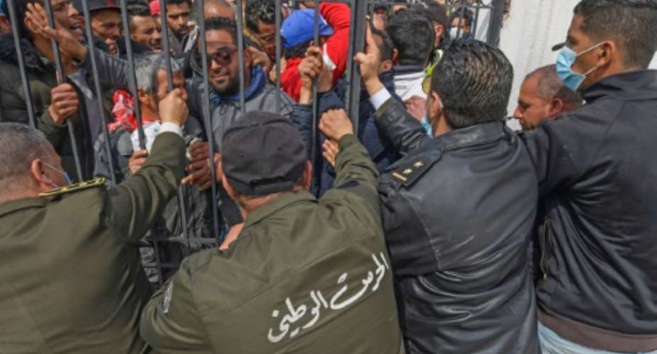 Tunisians angered by a coronavirus lockdown gather outside a government office on the outskirts of the capital.  By FETHI BELAID AFP