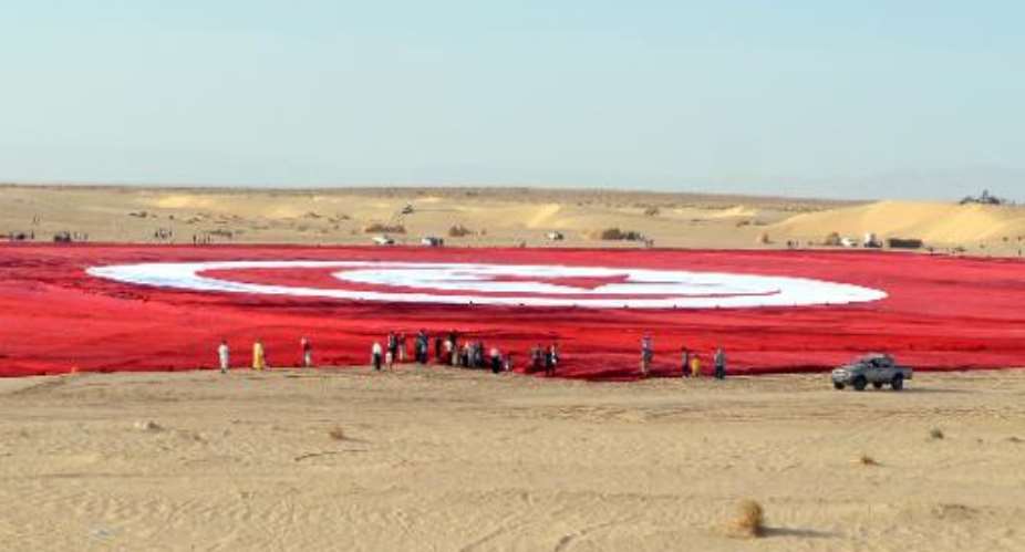A giant Tunisian national flag unfurled at Ong Jmel in the southern desert.  By Saif Trabelsi AFP