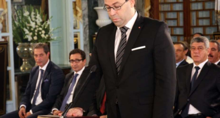 Tunisia's new Prime Minister Youssef Chahed takes an oath of office, during the country's new government swearing-in ceremony in Tunis on August 27, 2016.  By STRINGER TUNISIAN PRESIDENCYAFP