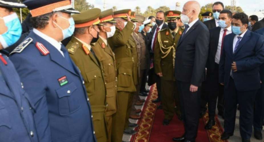 Tunisia's President Kais Saied C was received by Libya's new Head of the Presidential Council, Mohammad Menfi R, and military officials.  By STRINGER Tunisian presidency Facebook pageAFP