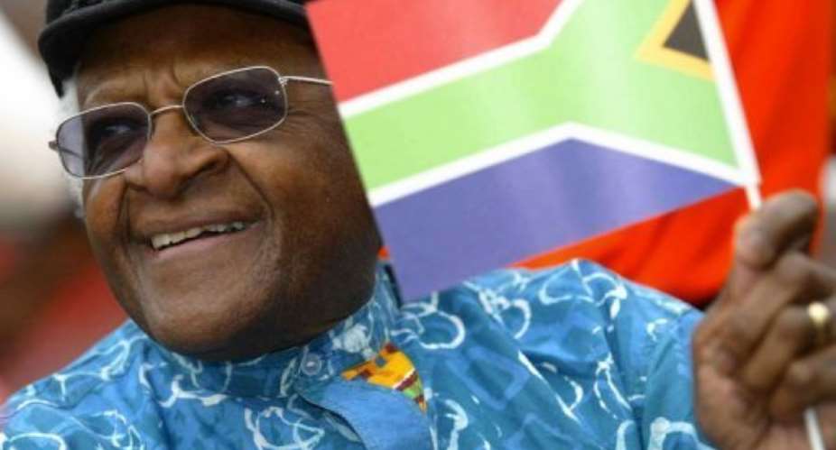 Desmond Tutu waves the South African flag in Londons Trafalgar Square on April 27, 2004 to mark Freedom Day.  By Carl de Souza (AFP/File)