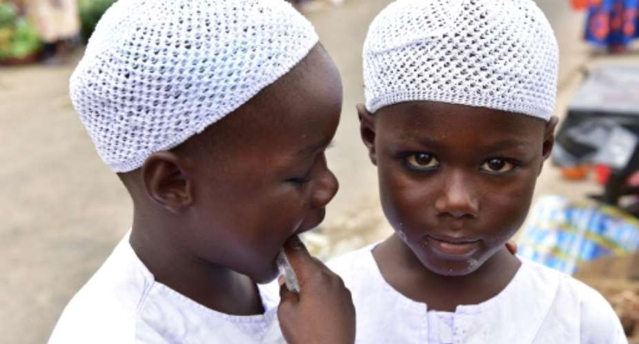 Twin brothers Salim and Mahamadou Cisse, just five years old, beg at the busy market of Abobo, a suburb of Ivory Coast's commercial capital Abidjan.  By ISSOUF SANOGO AFP