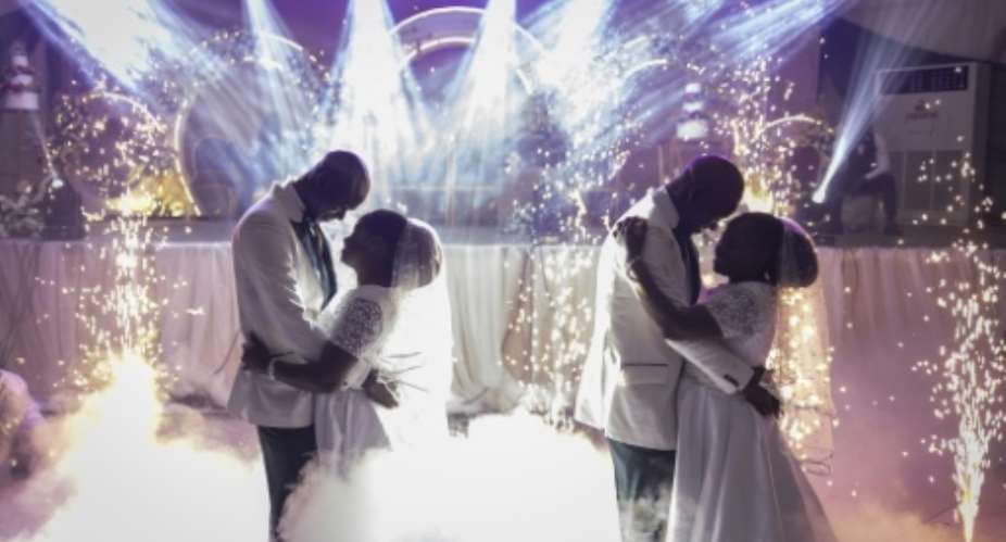 Twin brothers Taiwo and Kehinde Oguntoye dance with twin sisters Taiwo and Kehinde Adediran at their double wedding reception.  By OLYMPIA DE MAISMONT (AFP)