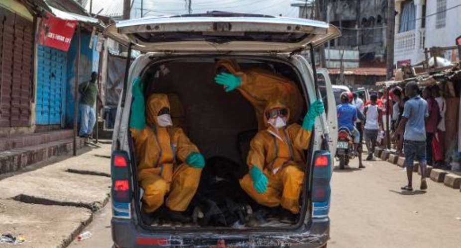 Volunteers arrive to pick up bodies of people who died of the Ebola virus in Freetown, Sierra Leone on October 8, 2014.  By Florian Plaucheur AFPFile