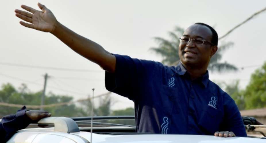 Central African presidential candidate Anicet Georges Dologuele waves from a car in a motorcarde during a presidential campaign tour in Bangui on December 28, 2015.  By Issouf Sanogo AFPFile