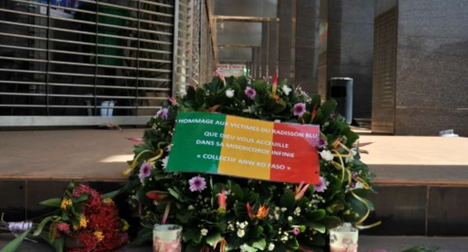 Tributes, including a wreath bearing the Mali flag, were left at the entrance to the Radisson Blu hotel in Bamako on 24, 2015 to honor the dead four days after a jihadi attack killed 27 there.  By Habibou Kouyate AFP