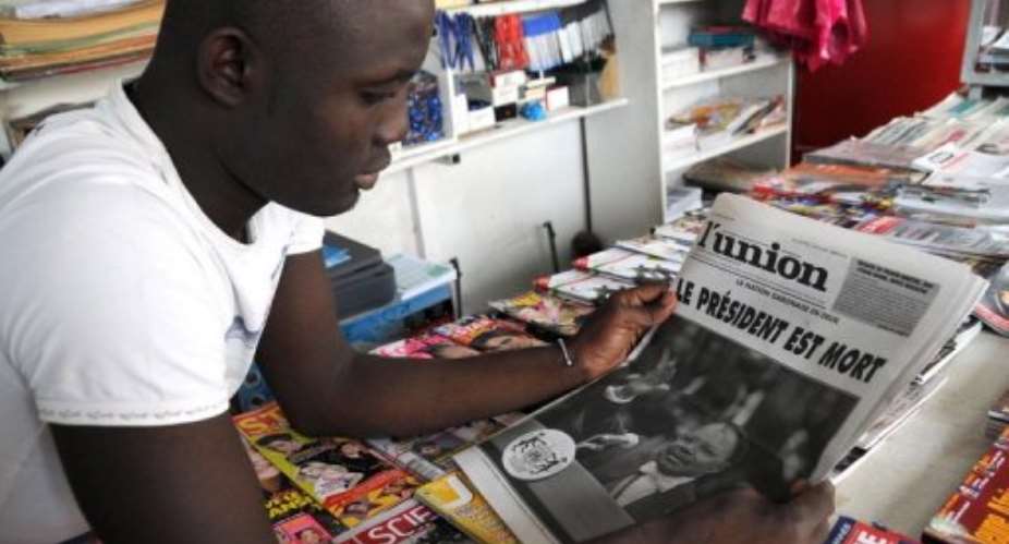 A young man reads a newspaper in Gabon.  By Wils Yanick Maniengui AFPFile