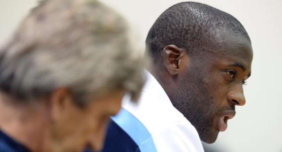 Manchester City midfielder Yaya Toure R attends a press conference in Moscow on October 21, 2013, on the eve of their Champions League match against CSKA Moscow.  By Alexander Nemenov AFPFile