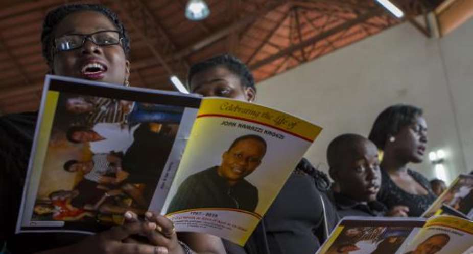 Children of the late acting assistant director of public prosecution Joan Kagezi attend a church service for their mother on April 2, 2015 in Kampala.  By Isaac Kasamani AFP