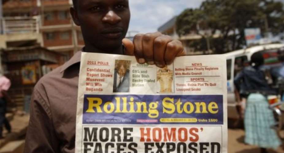 Giles Muhame, managing editor of Uganda's Rolling Stone newspaper, holds a 2010 edition naming 14 men it said were gay.  By Marc Hofer AFPFile