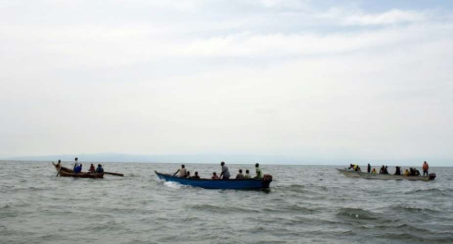 Uganda Police divers and local fishermen search for victims of a boat disaster on Lake Albert near Kitebere on March 23, 2013.  By Michele Sibiloni AFPFile