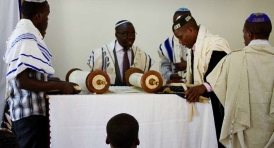 Rabbi Gershom C prepares to read the torah during the shabbat service among the Abayudaya Jewish community in a village near Mbale, eastern Uganda on July 2, 2016.  By Michael O'Hagan AFPFile
