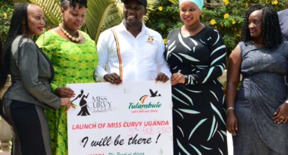 Uganda's Tourism Minister Godfrey Kiwanda posed with women during the launch of the Miss Curvy beauty contest in the capital Kampala.  By STRINGER AFP