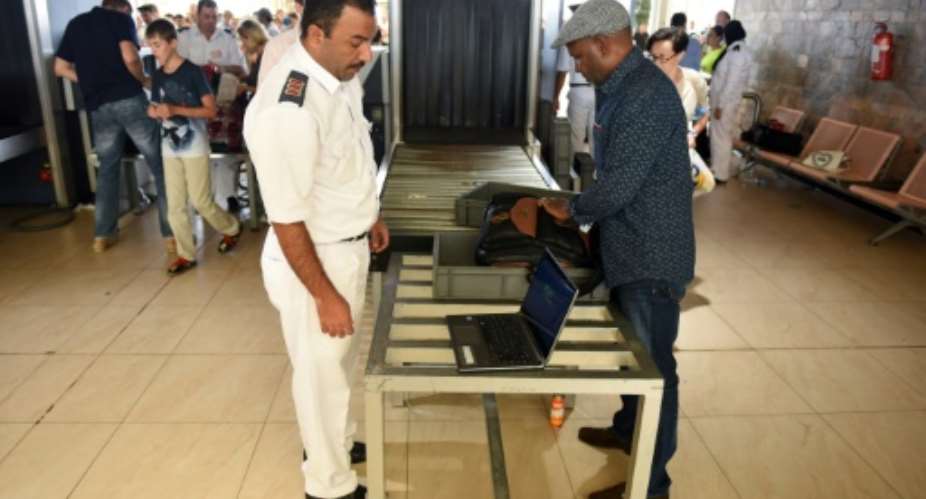 Airport security check a passenger's luggage as they pass through security in Egypt's Red Sea resort of Sharm El-Sheikh on November 6, 2015.  By Mohamed El-Shahed AFPFile