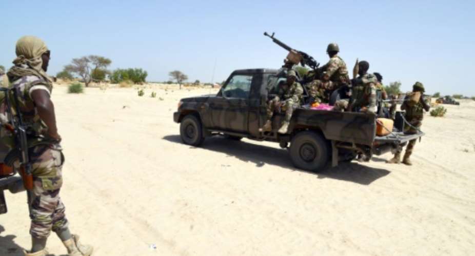 Niger soldiers ride in a military vehicle on May 25, 2015 in Malam Fatori, in northern Nigeria, where Niger and Chadian troops are working together in support of Nigerian forces to fight Boko Haram.  By Issouf Sanogo AFPFile