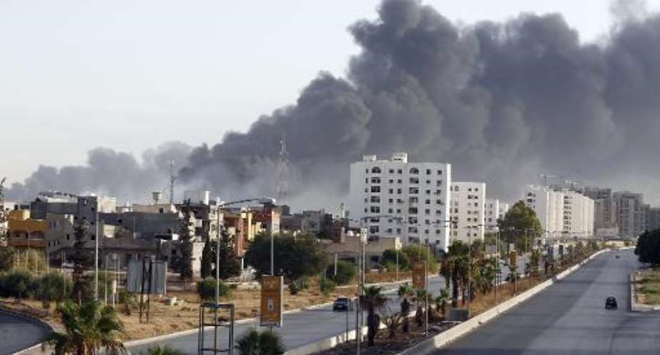 Black smoke billows across the sky after a petrol depot was set ablaze during clashes between rival militias near Tripoli's international airport on August 13, 2014.  By  AFPFile