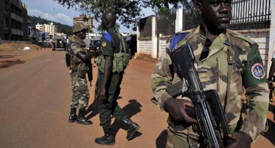 Soldier of the multinational African force FOMAC stands guard in front of a house on October 7, 2013 in Bangui.  By Issouf Sanogo AFPFile