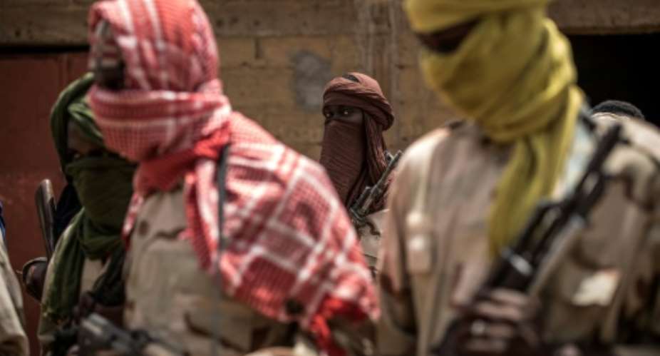Un groupe de miliciens peuls pose pour une photo avec leurs armes, le 6 juillet 2019, dans un camp de dmobilisation informel  Sevar, au Mali.  By Marco LONGARI (AFP)