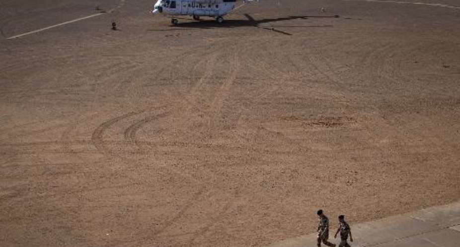 Soldiers walk near an United Nations helicopter on December 31, 2013 at a military base in Gao, northern Mali.  By Joel Saget AFPFile