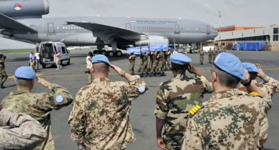 UN peacekeepers officials salute the coffins of two Dutch UN peacekeepers accidently killed, during a funeral ceremony on July 11, 2016 at the Bamako airport.  By Habibou Kouyate AFPFile