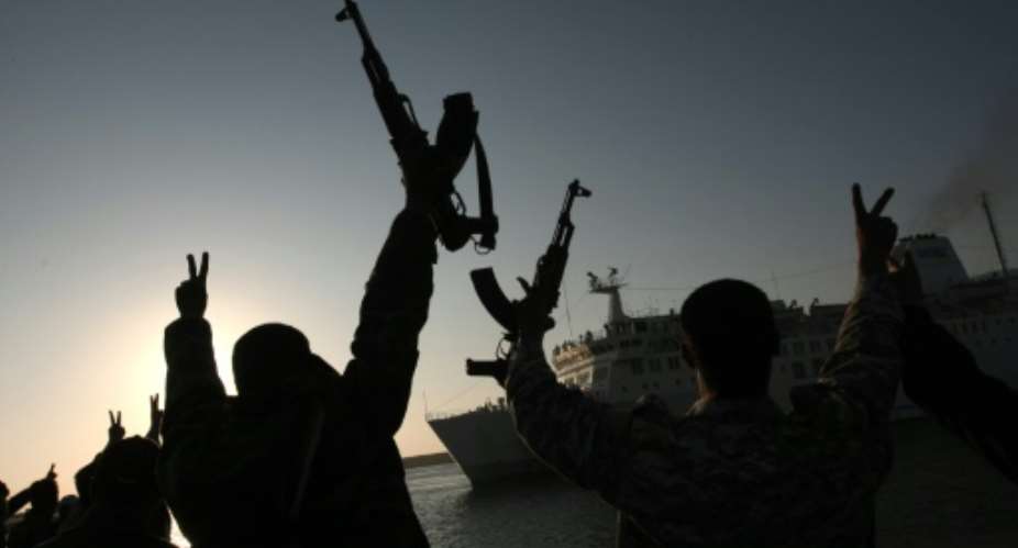 Rebel fighters hold their weapons aloft to welcome a Turkish ship arriving from Misrata to the port of Benghazi to evacuate the wounded on April 3, 2011.  By Mahmud Hams AFPFile