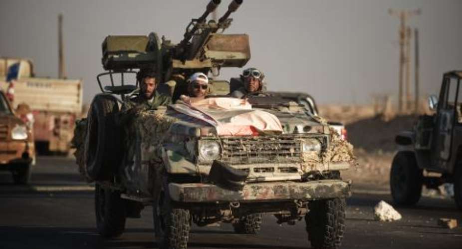 Libyan rebels drive a vehicle mounted with an anti-aircraft gun as they head from Ras Lanuf to the Bin Jawad frontline on August 26, 2011.  By Gianluigi Guercia AFPFile
