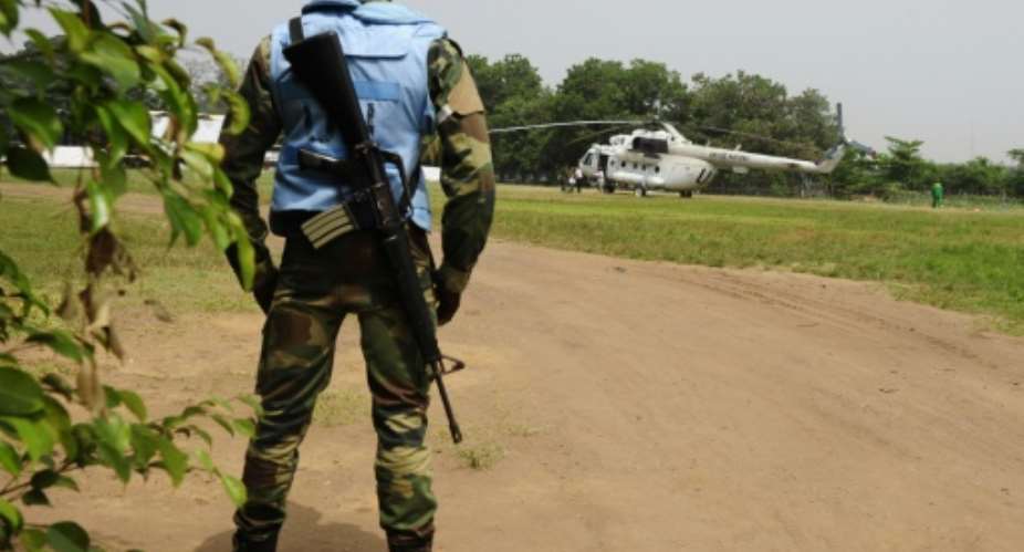A UN peacekeeper in Abidjan, Ivory Coast stands guard by a UN helicopter used to transport officials and journalists on January 3, 2011.  By Issuof Sanogo AFPFile