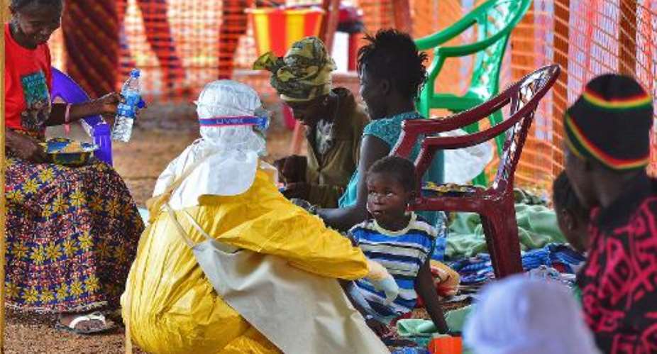An MSF medical worker feeds an Ebola victim at an MSF facility in Kailahun, on August 15, 2014.  By Carl de Souza AFPFile