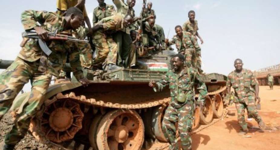 Sudanese soldiers pose on a seized tank in the oil region of Heglig in April 2012.  By Ashraf Shazly (AFP/File)
