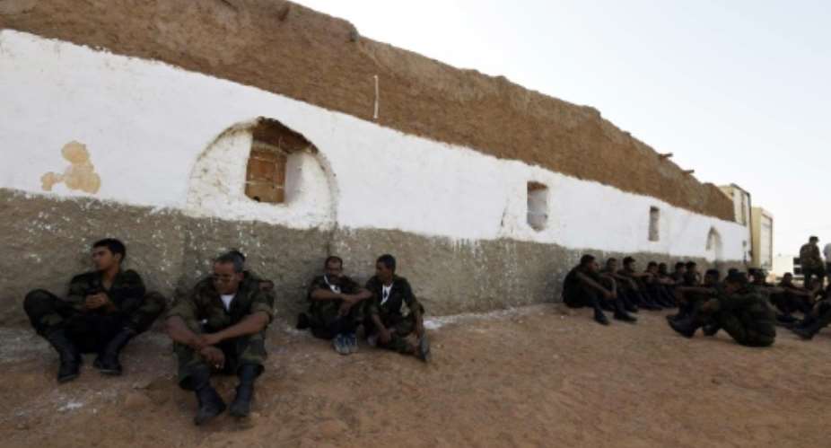Members of the Sahrawi People's Liberation Army sit waiting outside a building during the Polisario Front's extraordinary congress on July 8, 2016.  By Farouk Batiche AFPFile