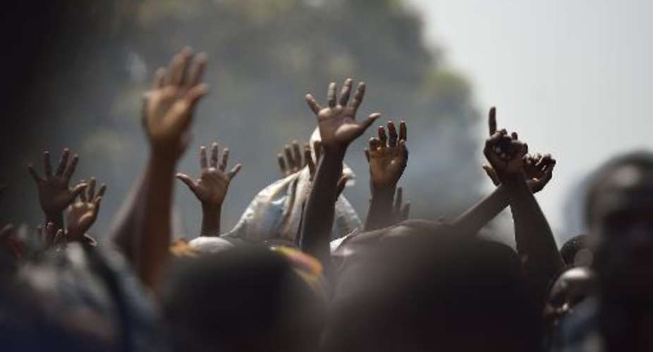 Displaced people raise their hands as they wait for food distribution, near Mpoko Bangui's airport where 100,000 people have found shelter on January 8, 2014.  By Eric Feferberg AFPFile