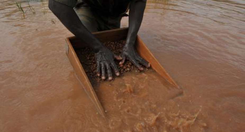 A man sifts through pebbles searching for diamonds in the village of Bobi, north western Ivory Coast, on November 18, 2009.  By Issouf Sanogo AFPFile