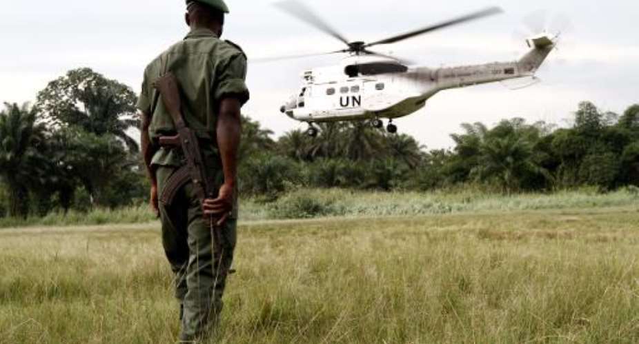 This picture taken on September 3, 2013 shows a soldier of the Congolese Defense Forces FARDC watching a UN helicopter from the MONUSCO taking off from Walikale in the Democratic Republic of Congo.  By Marc Hofer AFPFile