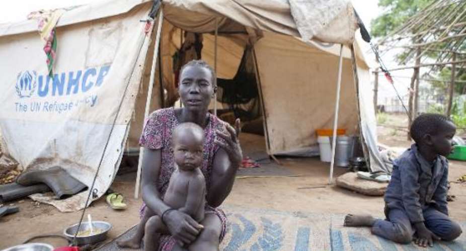A woman and her children displaced by fighting in South Sudan sit outside her tent at the Kule camp for Internally Displaced People at the Pagak border crossing in Gambella, Ethiopia, on July 10, 2014.  By Zacharias Abubeker AFPFile