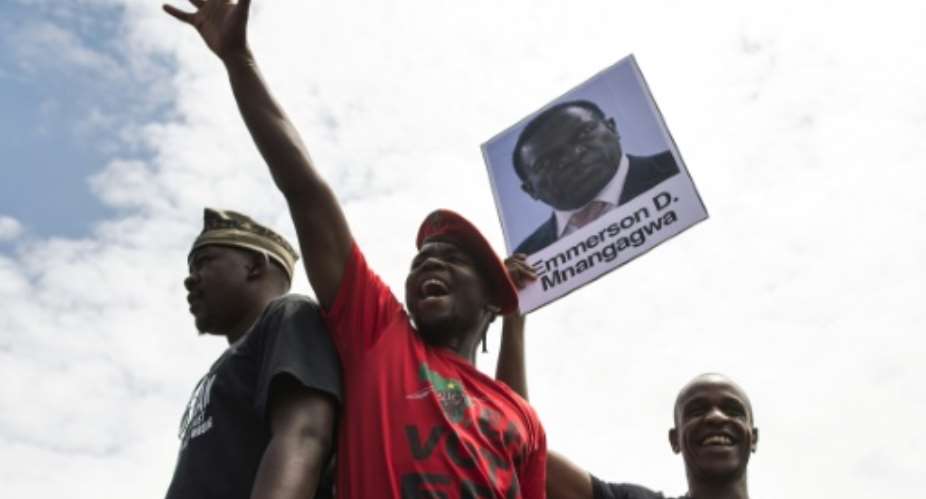 University of Zimbabwe students with a portrait of ousted vice president Emmerson Mnangagwa at a demonstration in Harare on Monday.  By - AFP