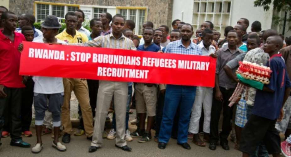 Burundian protesters hold banners at Bujumbura airport on January 21, 2016.  By Griff Tapper AFPFile
